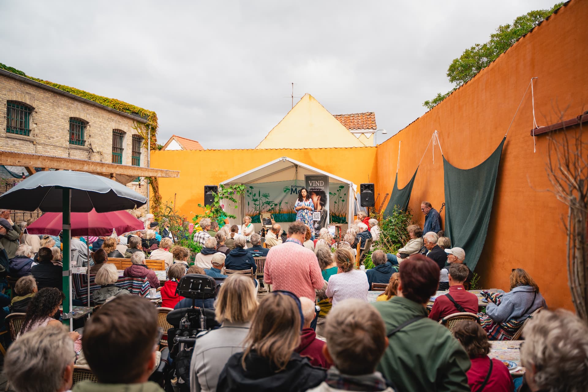 Mennesker mødes til samtaler og kultur i et åbent gårdrum